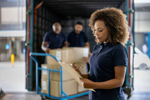 Logistics professional checking manifest at loading dock